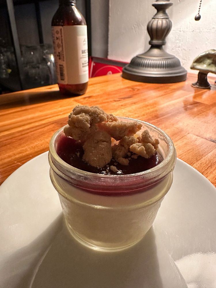Panna cotta in a glass jar with fruit and crumble