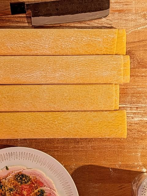 Sheets of fresh egg pasta on a wooden board